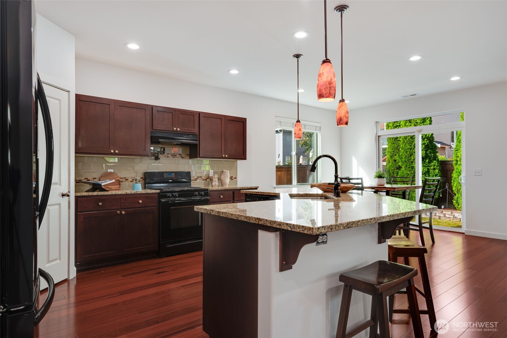 17026 Southeast 263rd Street Covington, WA 98042 - Photo 8 of 40 a kitchen with stainless steel appliances granite countertop a sink refrigerator and cabinets