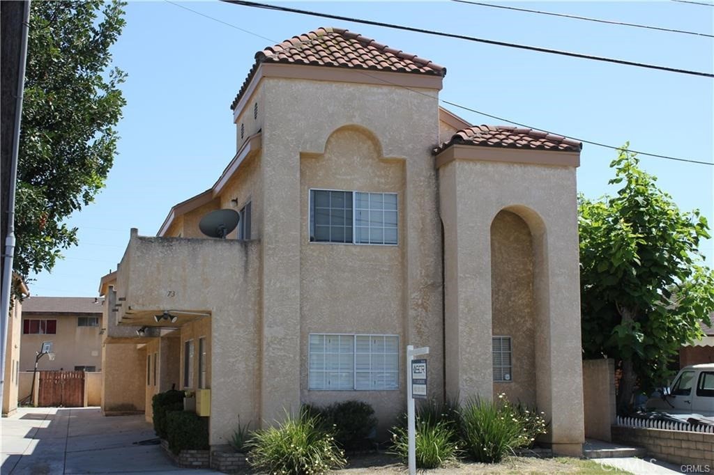 a front view of a house with plants