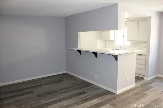 a room with wooden floor and sink
