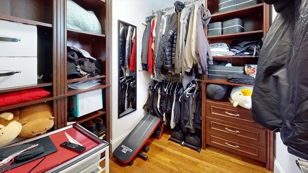 a view of walk in closet with clothes and shoes