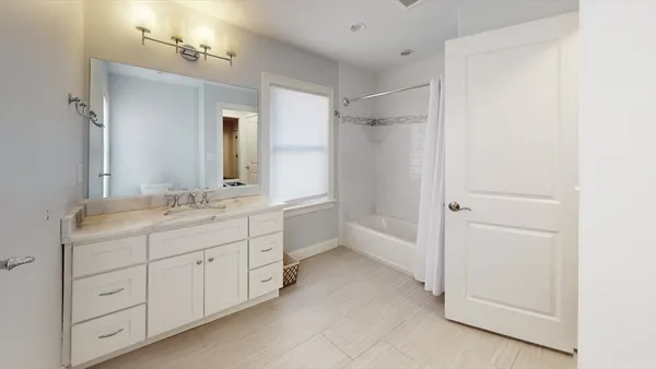 a bathroom with a double vanity sink a mirror and a bathtub