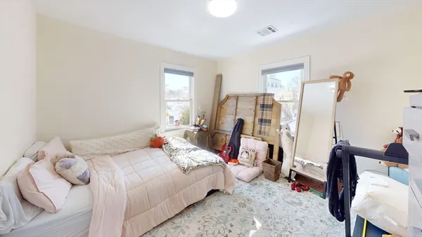 a bedroom with a bed a large window and chair