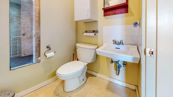 a bathroom with a sink toilet and a mirror