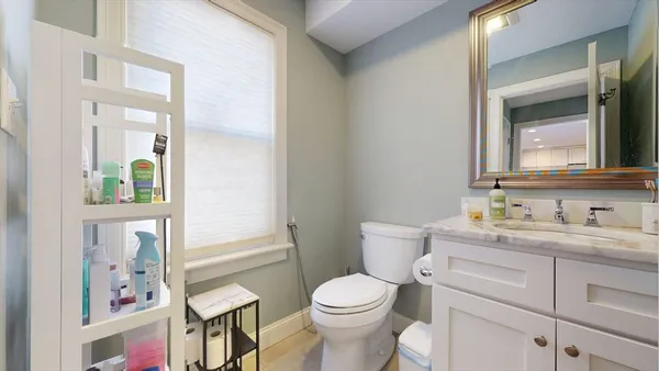 a bathroom with a toilet a sink and mirror