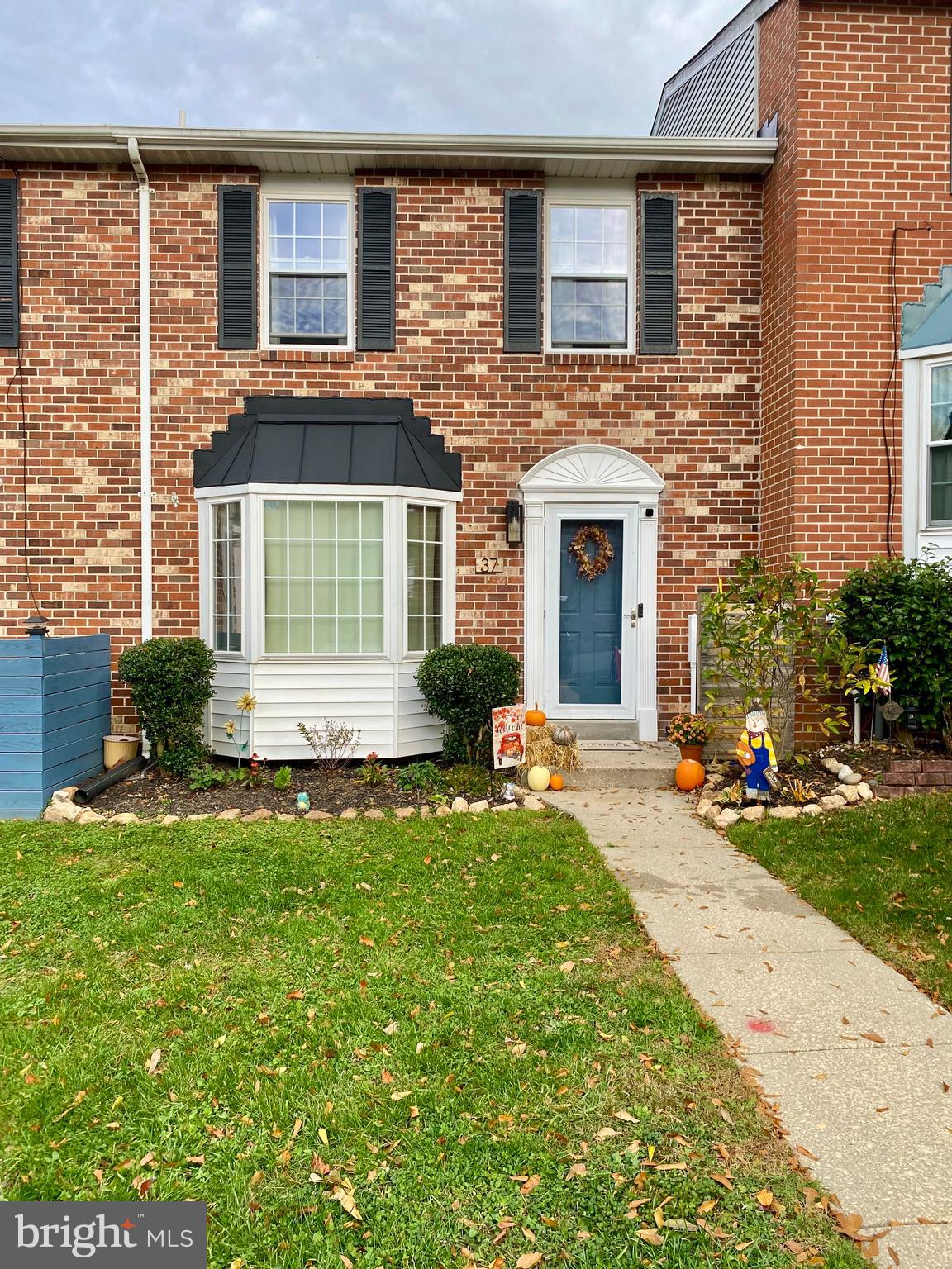 front view of a house with a yard and a large window