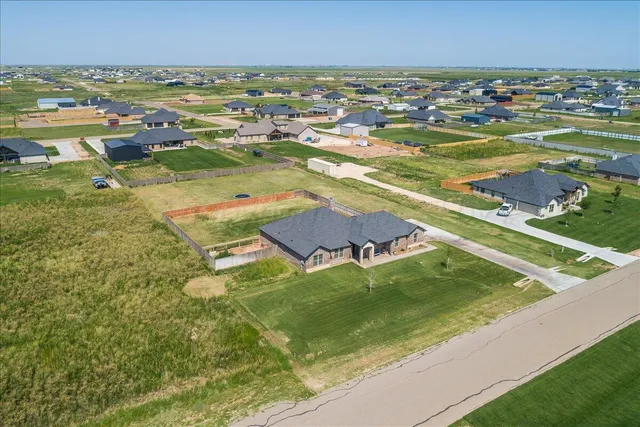 an aerial view of a residential houses with outdoor space and river