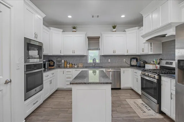 a bathroom with a granite countertop double vanity sink and mirror