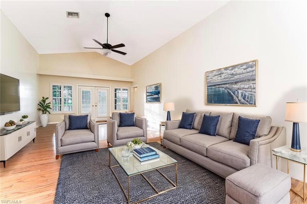 3988 Reflection Court Naples, FL 34109 - Photo 17 of 50 Living area with light wood finished floors, a ceiling fan, french doors, and high vaulted ceiling