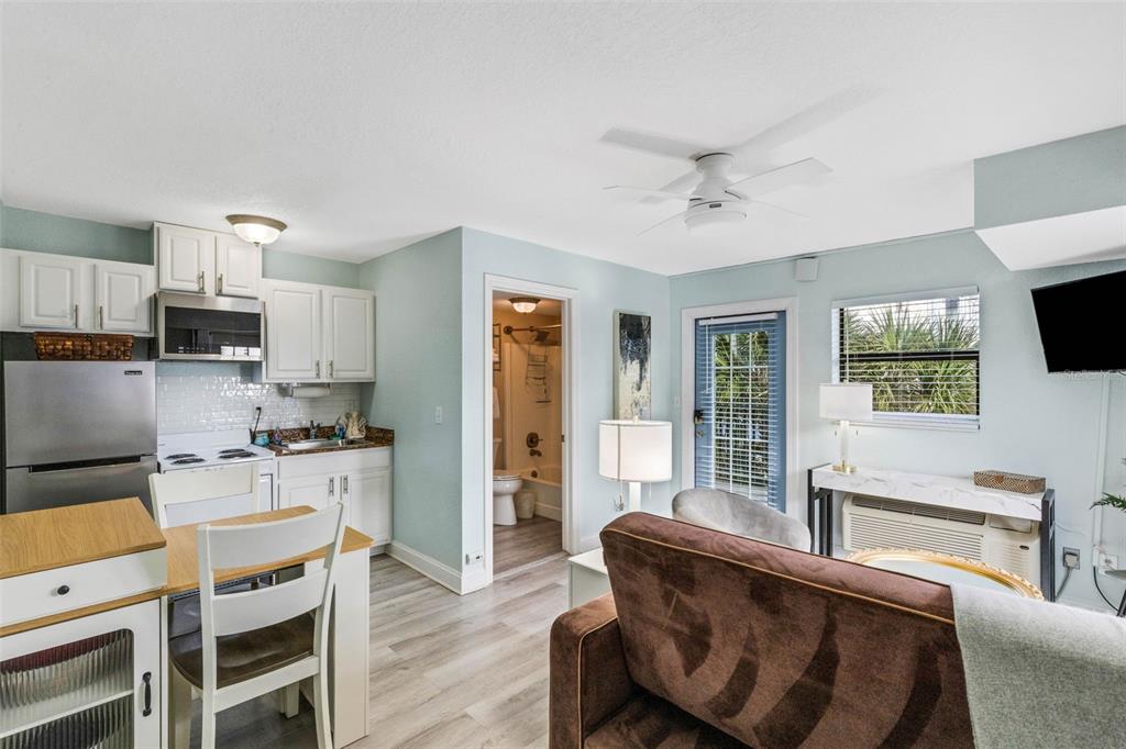 16333 Gulf Boulevard, Unit 215 Redington Beach, FL 33708 - Photo 12 of 38 a living room with furniture a flat screen tv and kitchen view
