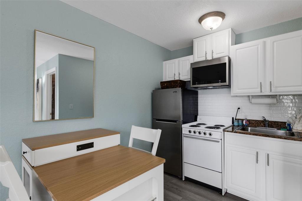 16333 Gulf Boulevard, Unit 215 Redington Beach, FL 33708 - Photo 15 of 38 a kitchen with white cabinets stainless steel appliances and sink