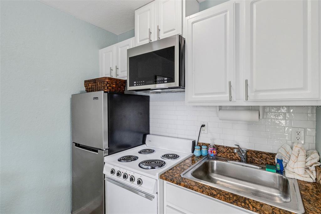 16333 Gulf Boulevard, Unit 215 Redington Beach, FL 33708 - Photo 16 of 38 a kitchen with a stove and a microwave
