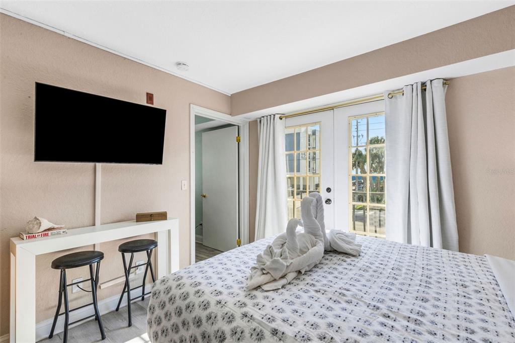 16333 Gulf Boulevard, Unit 215 Redington Beach, FL 33708 - Photo 22 of 38 a bedroom with a bed and a flat screen tv