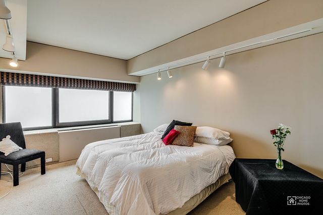 175 East Delaware Place, Unit 5609 Chicago, IL 60611 - Photo 16 of 28 a bedroom with a bed and a window