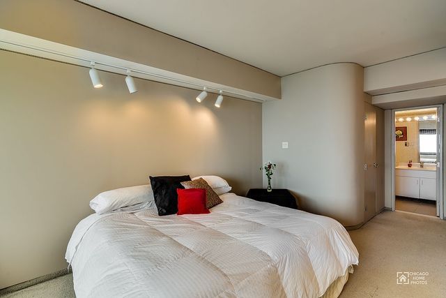 175 East Delaware Place, Unit 5609 Chicago, IL 60611 - Photo 17 of 28 a bedroom with a bed and wooden floor