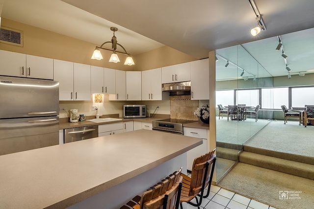 175 East Delaware Place, Unit 5609 Chicago, IL 60611 - Photo 8 of 28 a kitchen with stainless steel appliances a stove a sink a microwave a refrigerator and cabinets