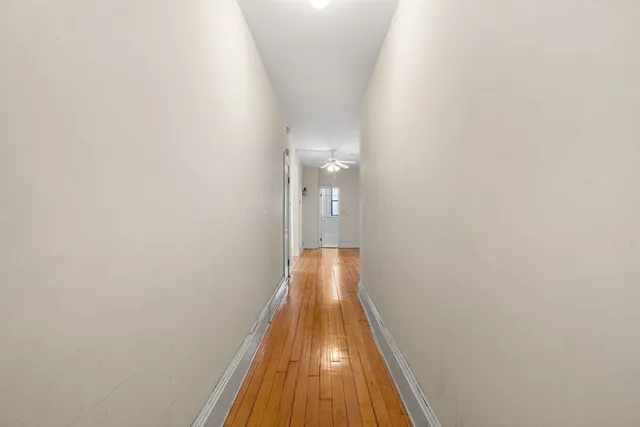 a view of a hallway with wooden floor
