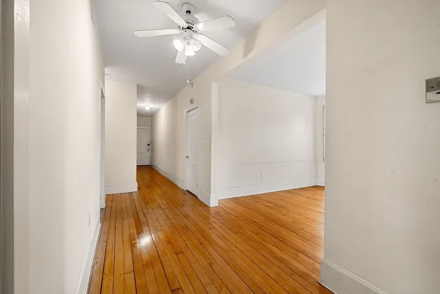 a view of a hallway with wooden floor