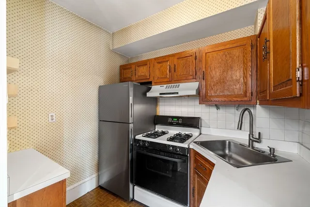 a kitchen with stainless steel appliances granite countertop a sink stove and refrigerator