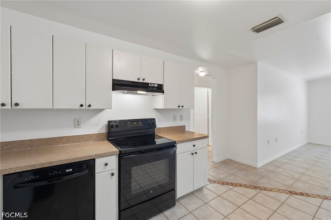 221 Meadow Road Lehigh Acres, FL 33973 - Photo 3 of 13 a kitchen with a sink stove and cabinets