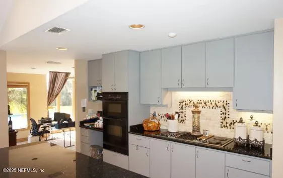 a kitchen with stainless steel appliances granite countertop a sink a stove a refrigerator and island