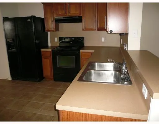 a kitchen with granite countertop a refrigerator and a stove