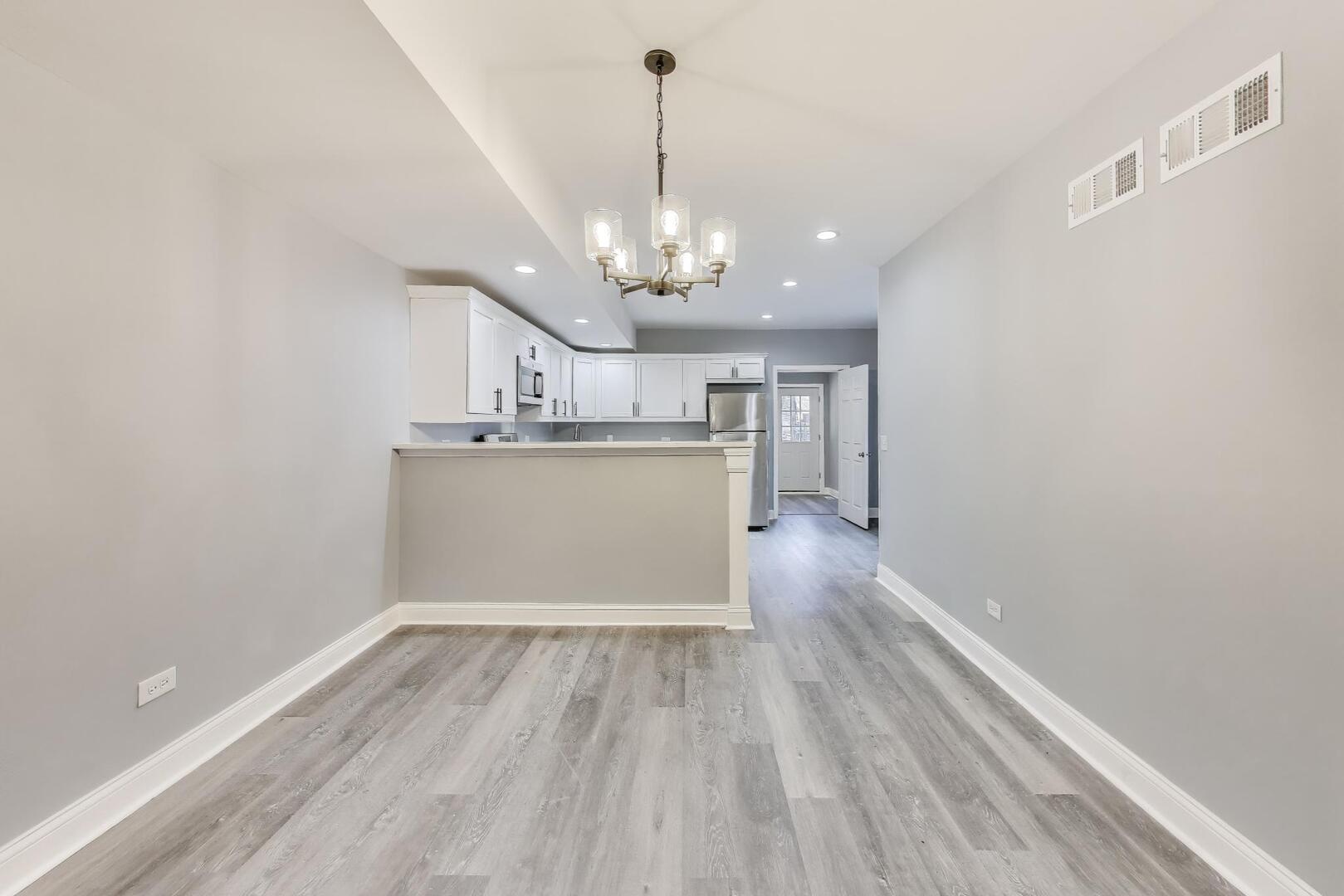 Undisclosed Address Chicago, IL 60622 - Photo 7 of 33 a view of a room with wooden floor and kitchen view