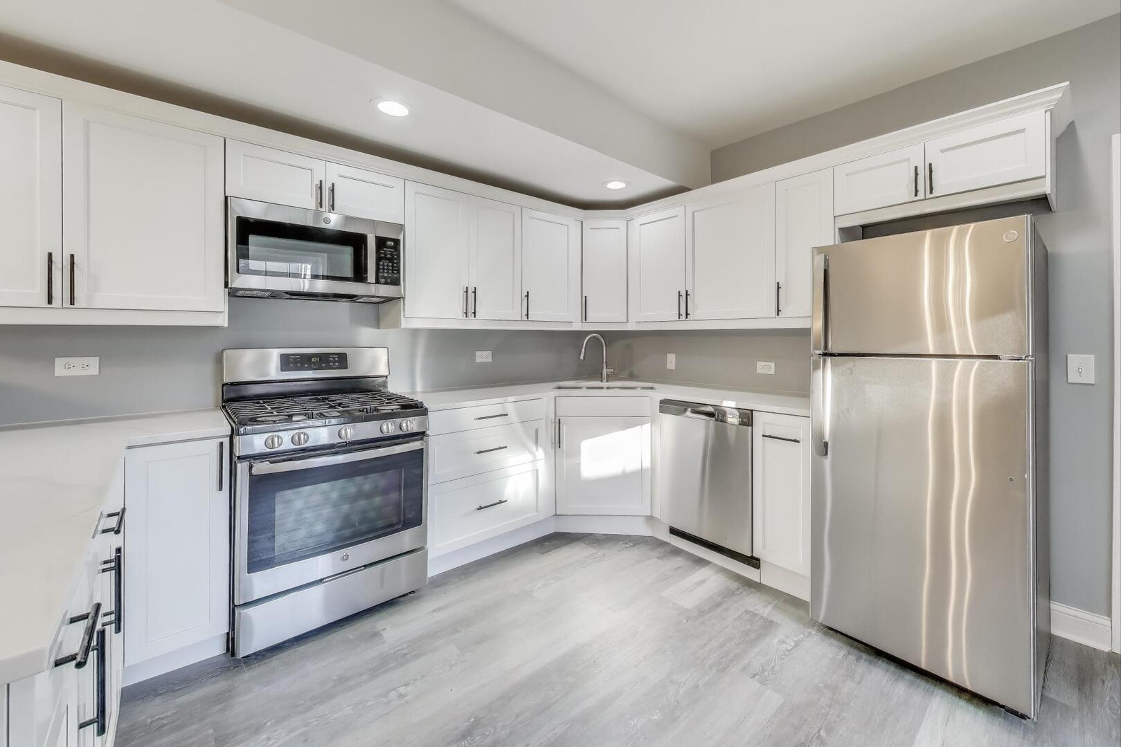 Undisclosed Address Chicago, IL 60622 - Photo 10 of 33 a kitchen with white cabinets and white appliances