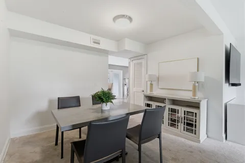 a kitchen with stainless steel appliances a dining table and chairs