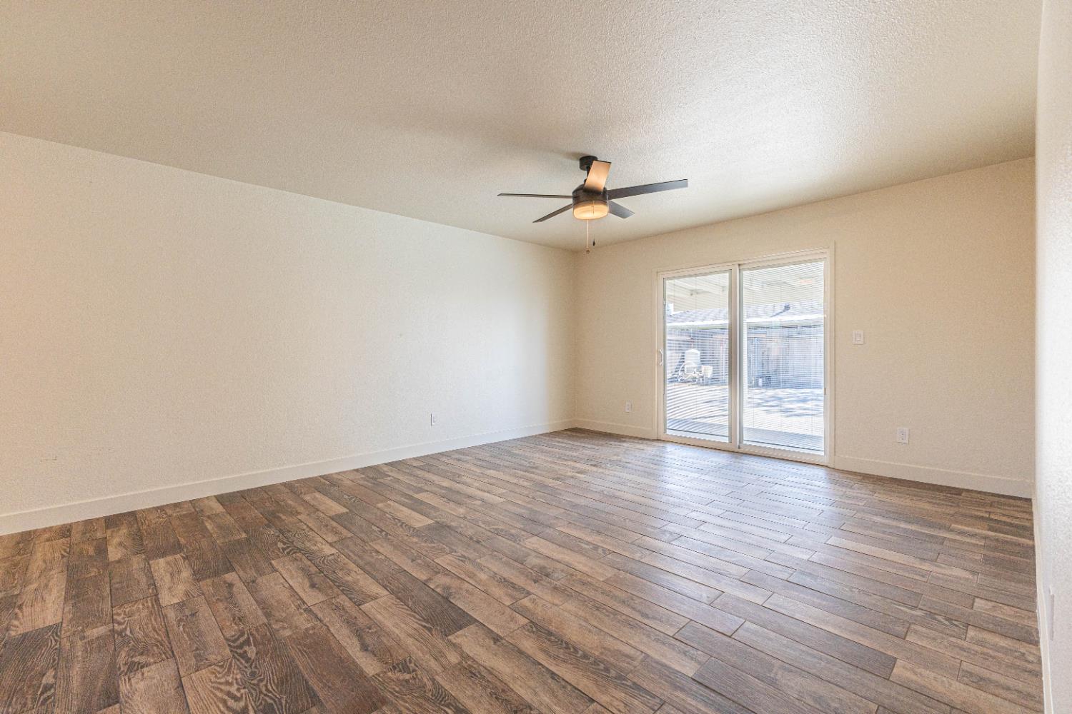 300 Walnut Street Madera, CA 93637 - Photo 2 of 12 a view of an empty room with a window and wooden floor