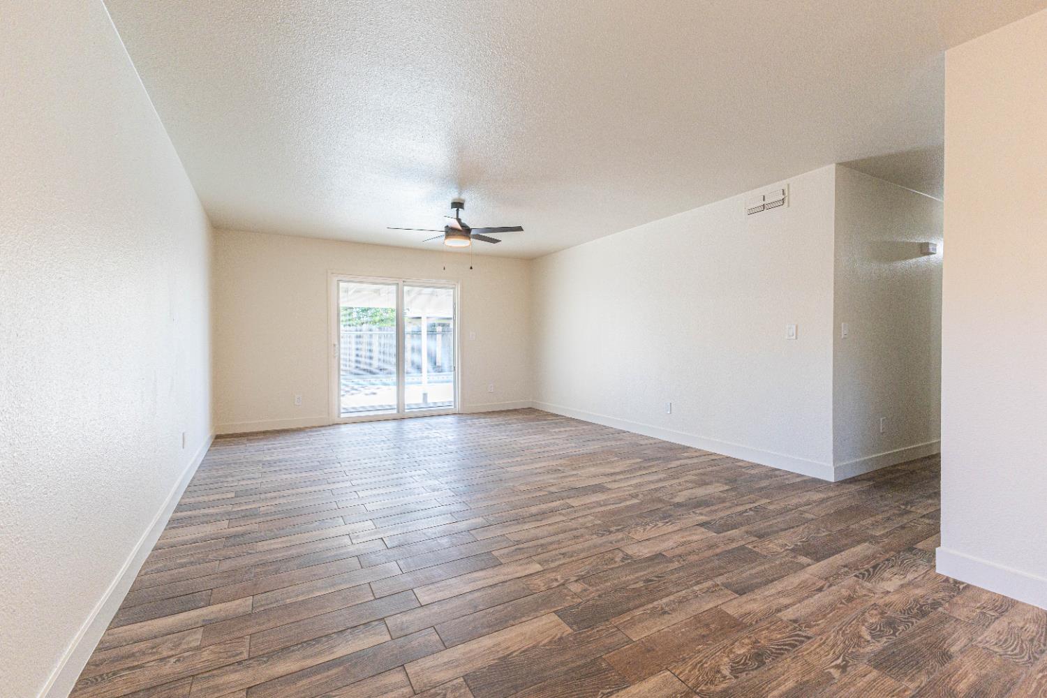 300 Walnut Street Madera, CA 93637 - Photo 3 of 12 a view of an empty room with wooden floor and a window