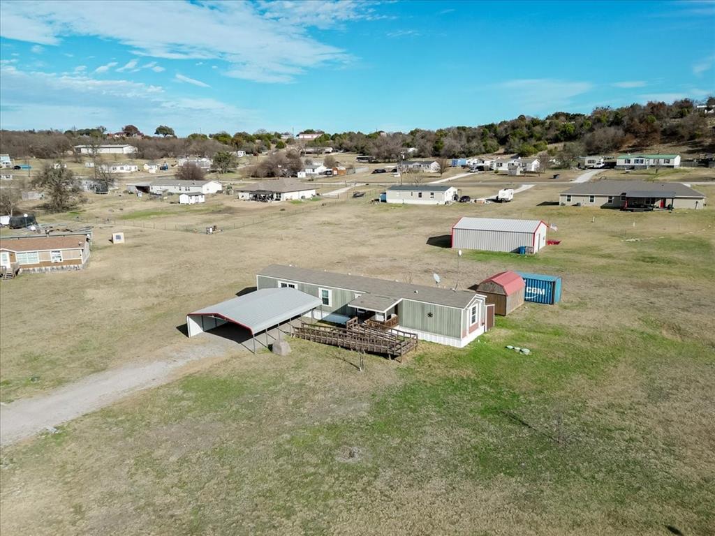 126 Starry Sky Court Springtown, TX 76082 - Photo 19 of 34 View of subject property, Car port, Wood shed and storage container convey with the property.