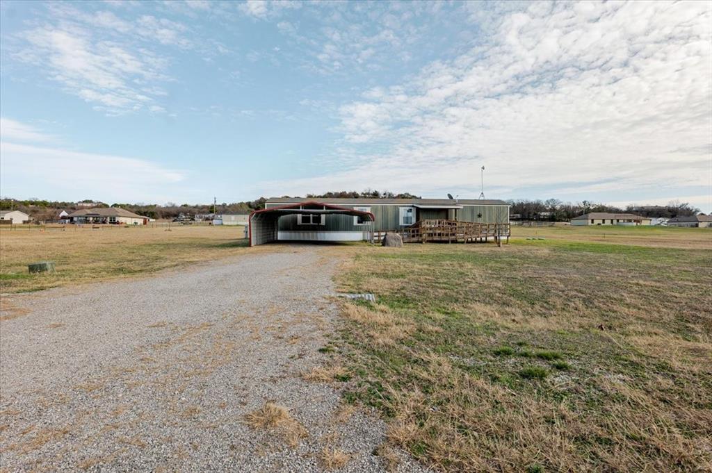 126 Starry Sky Court Springtown, TX 76082 - Photo 2 of 34 Manufactured / mobile home with driveway, a front yard, and a carport