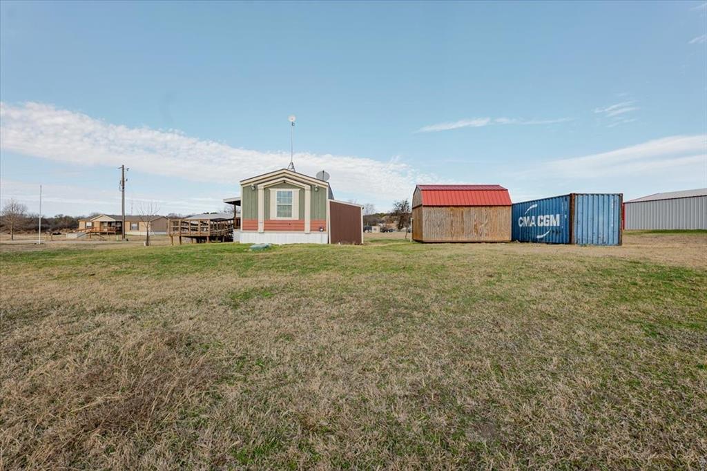 126 Starry Sky Court Springtown, TX 76082 - Photo 29 of 34 View of green lawn with an outbuilding
