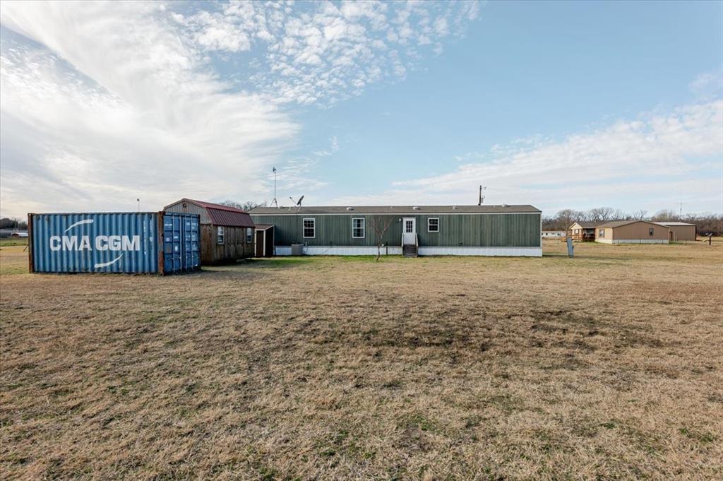 126 Starry Sky Court Springtown, TX 76082 - Photo 31 of 34 Back of property with a yard and an outdoor structure