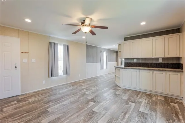 a view of a kitchen with a sink and dishwasher a refrigerator with wooden floor