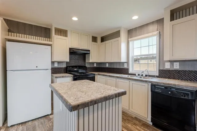 a kitchen with a stove a sink and a refrigerator