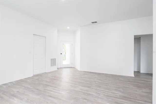 a view of an empty room with wooden floor