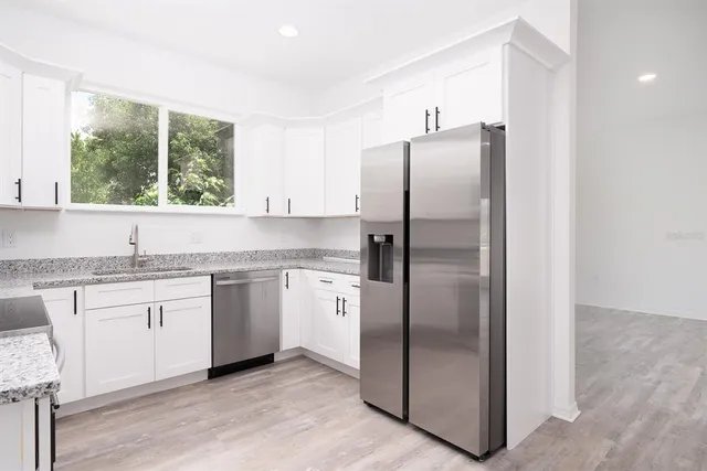 a kitchen with stainless steel appliances granite countertop a refrigerator and a sink