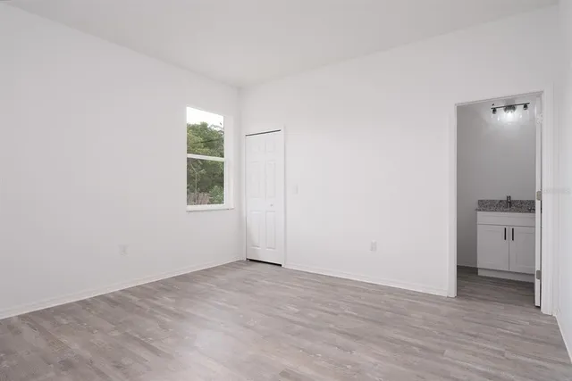 an empty room with a window and wooden floor