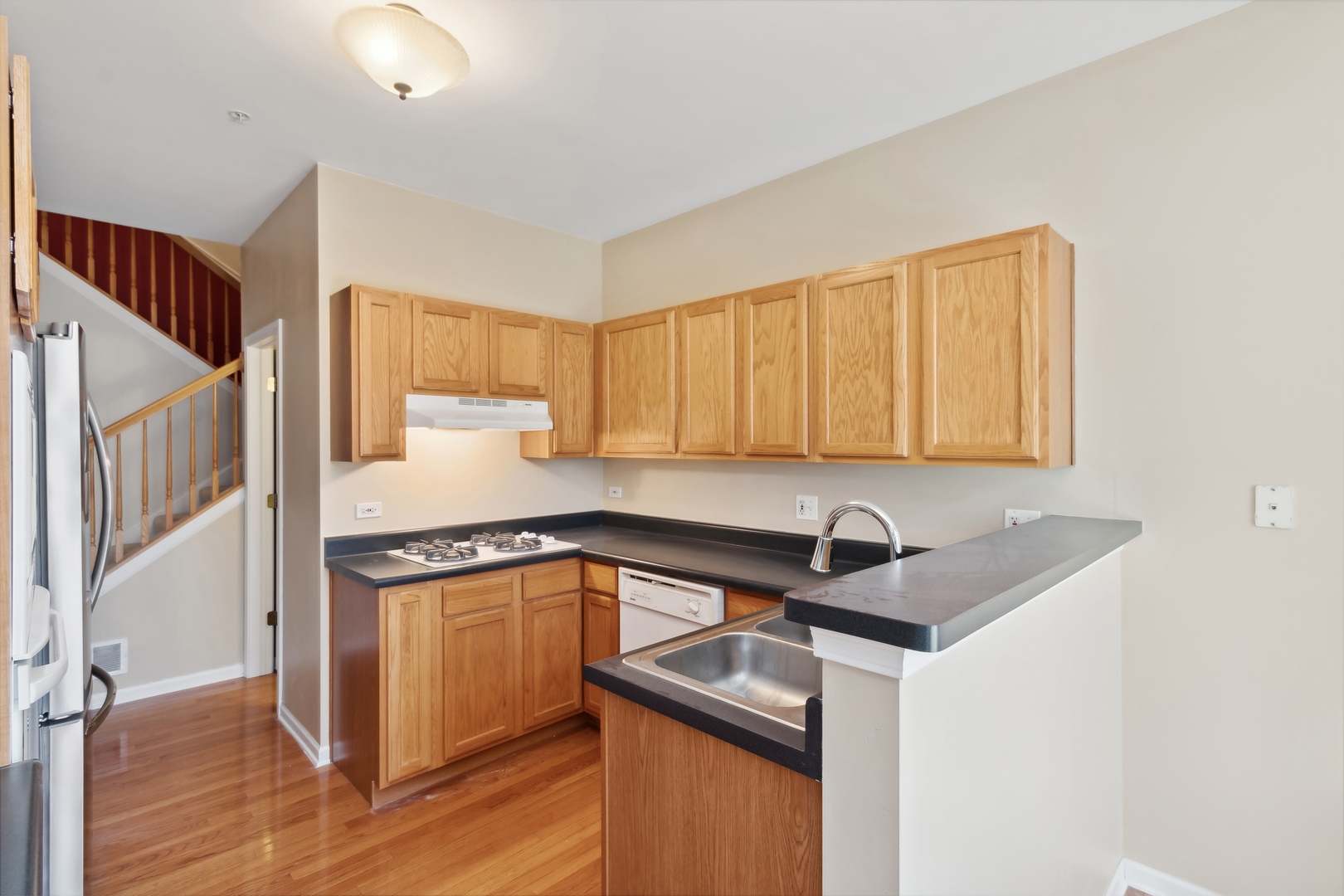 5471 McDonough Road Hoffman Estates, IL 60192 - Photo 9 of 32 a kitchen that has a sink and a stove with wooden floor