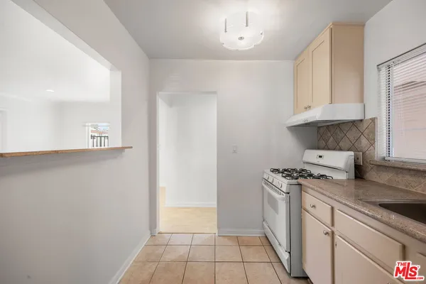 a kitchen with a stove top oven a sink a counter space and cabinets