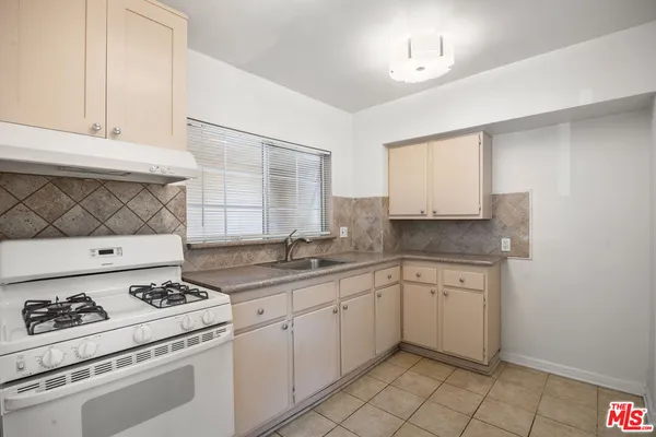 a kitchen with a stove cabinets and sink