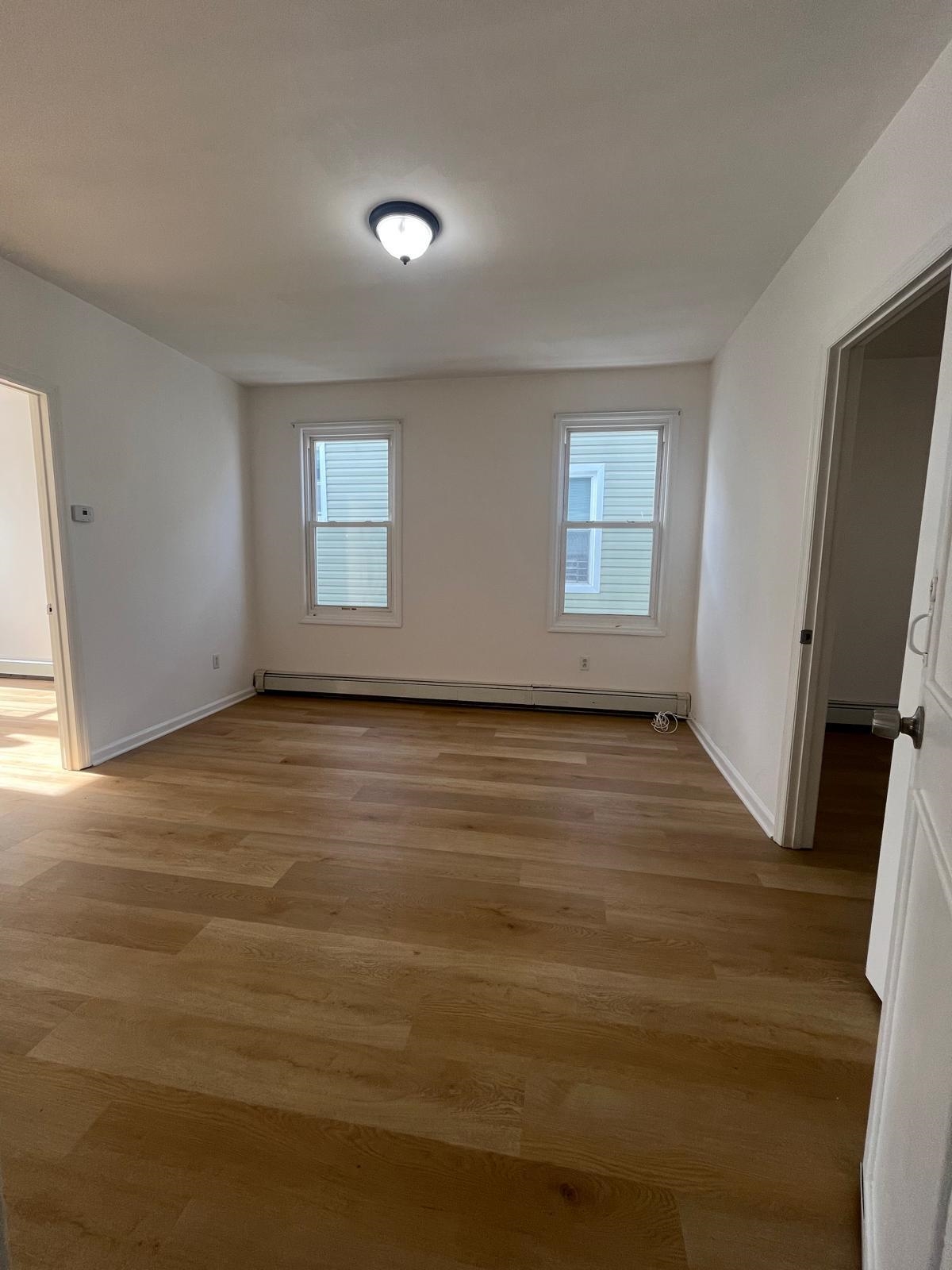 88 Devon Terrace, Unit 2 Kearny, NJ 07032 - Photo 5 of 13 an empty room with wooden floor and windows
