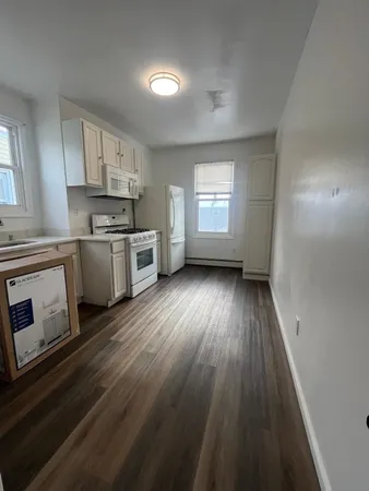 a view of kitchen with sink wooden floor and stainless steel appliances