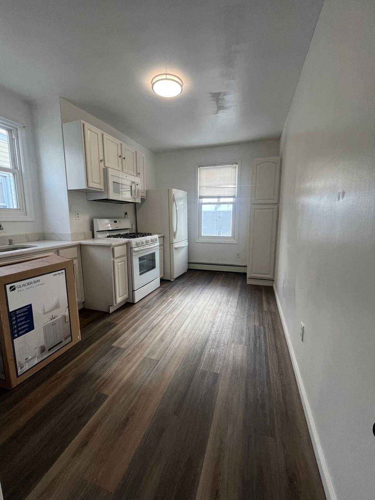 88 Devon Terrace, Unit 2 Kearny, NJ 07032 - Photo 7 of 13 a view of kitchen with sink wooden floor and stainless steel appliances