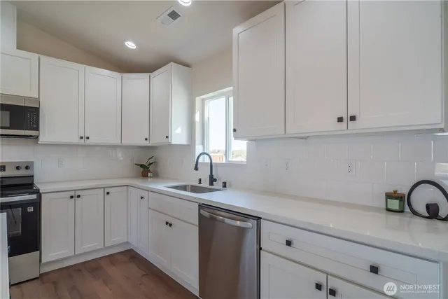 a view of a kitchen and an empty room