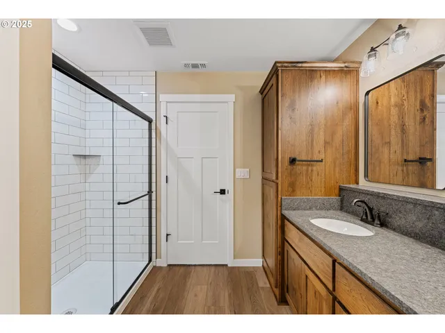 a bathroom with a granite countertop sink mirror and shower