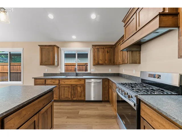 a kitchen with stainless steel appliances granite countertop a sink stove and cabinets