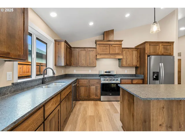 a kitchen with stainless steel appliances granite countertop a sink stove and refrigerator