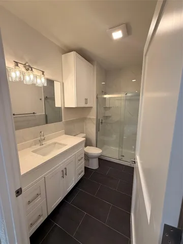 a bathroom with a double vanity sink toilet and shower